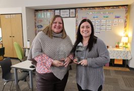 two women smiling, each holding an award