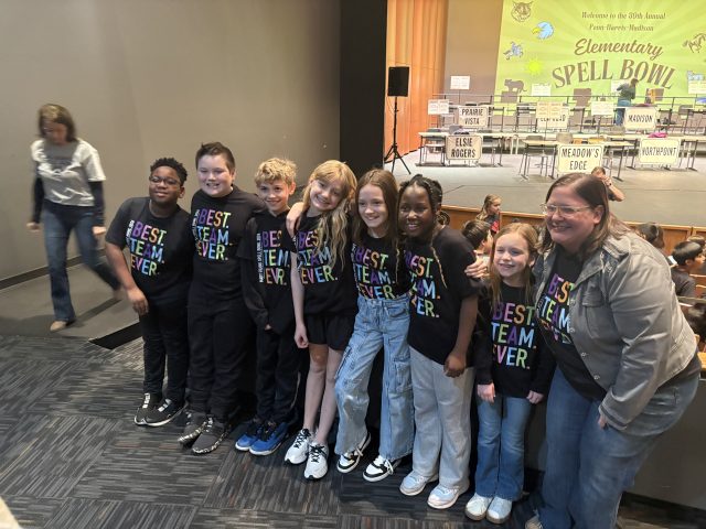 Group of children posing for a picture on a stage.