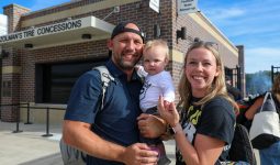 A family posing in front of a building with a sign that reads 'Tire Concessions'.