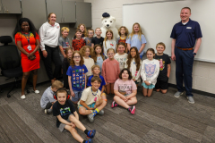 People posing in a classroom setting with a stuffed polar bear.